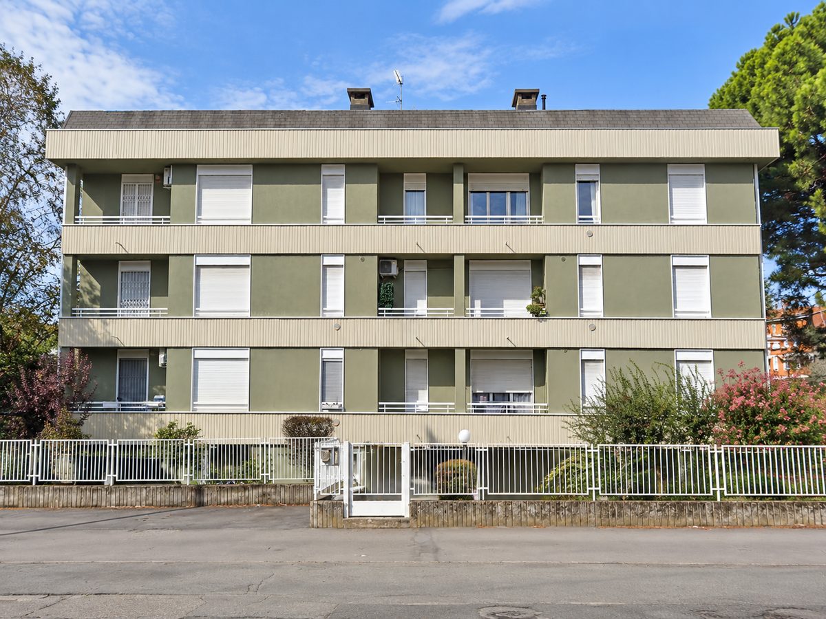 Condominio a tre piani con facciata bicolore verde e sabbia e balconi continui dopo il rifacimento, San Vittore Olona (MI)