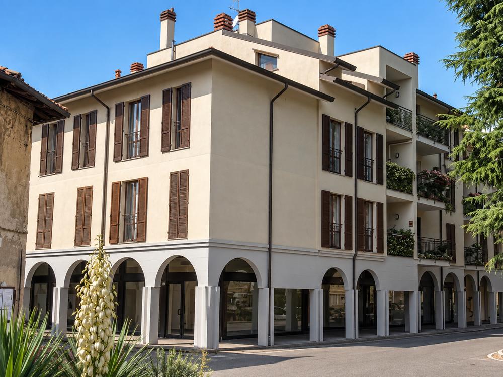 Edificio residenziale d’angolo con portico ad arcate e persiane in legno, Busto Garolfo (MI)
