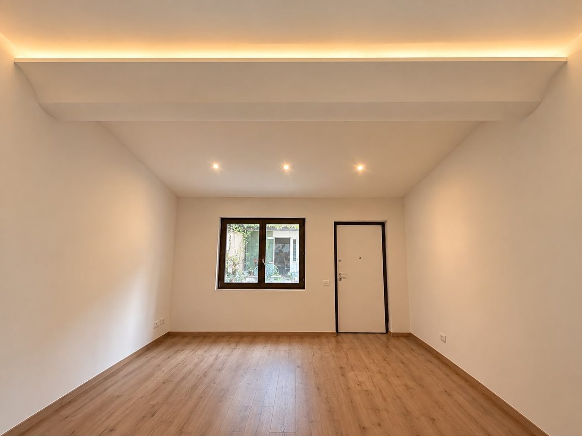 Soggiorno finito con velette luminose a soffitto, faretti e pavimento in laminato, Legnano (MI)